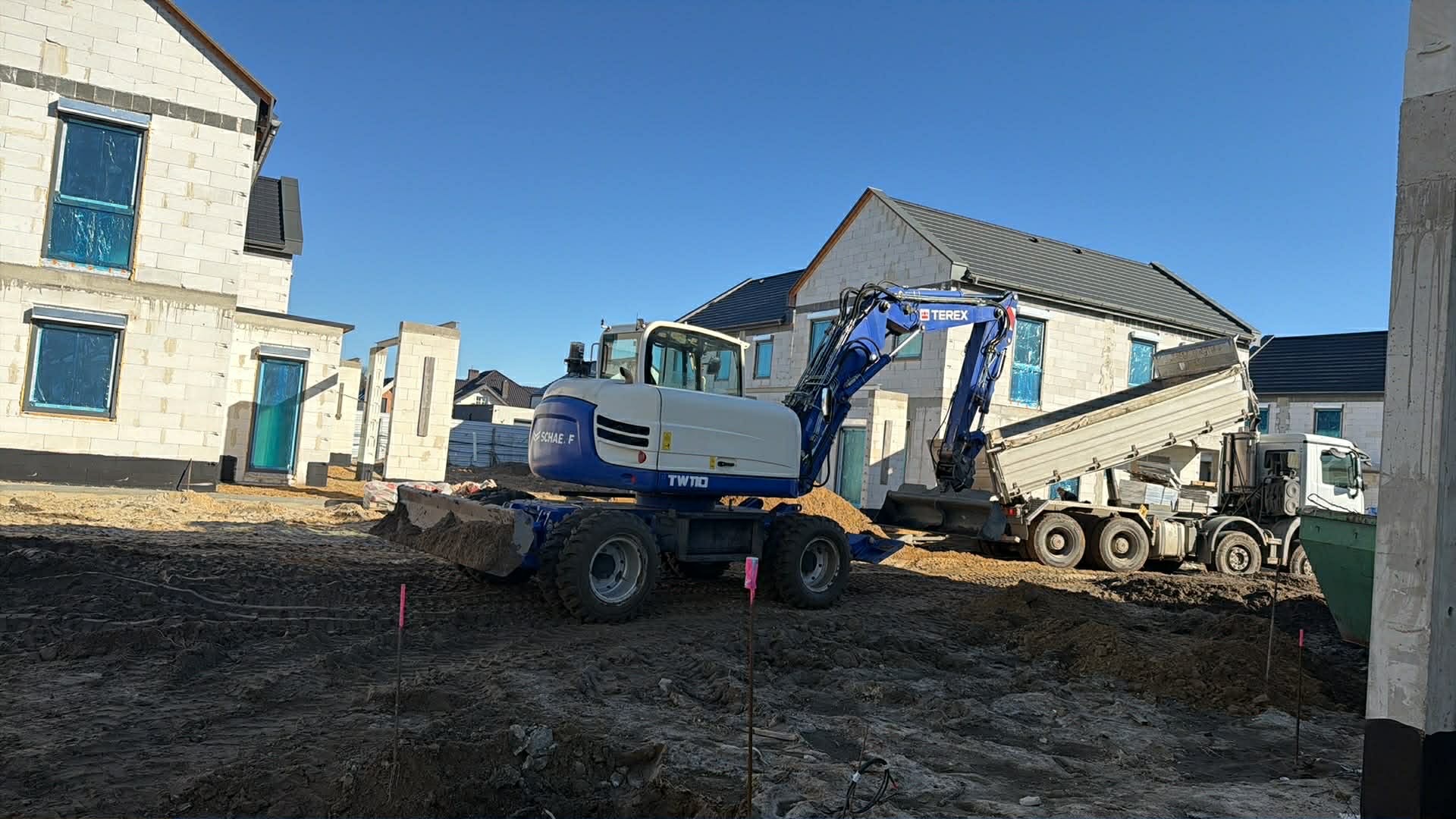 Koparka przy samochodzie – ładunek ziemi